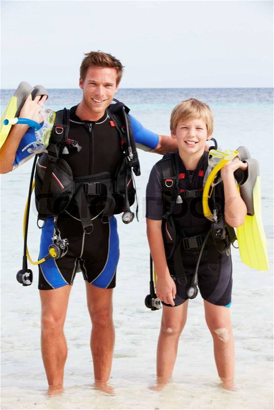 Father And Son With Scuba Diving Equipment On Beach Holiday, stock photo