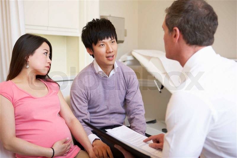 Couple Meeting With Obstetrician In Clinic, stock photo
