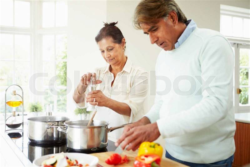 Senior Indian Couple Cooking Meal At Home, stock photo