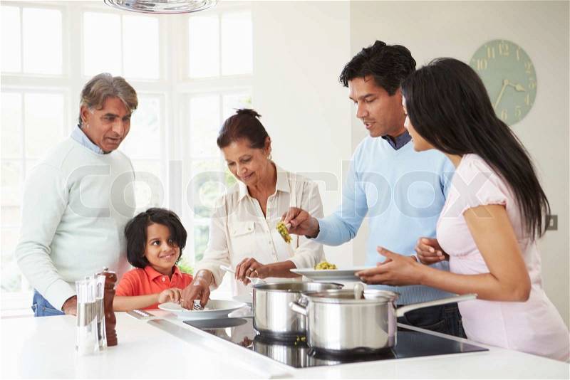 Multi Generation Indian Family Cooking Meal At Home, stock photo