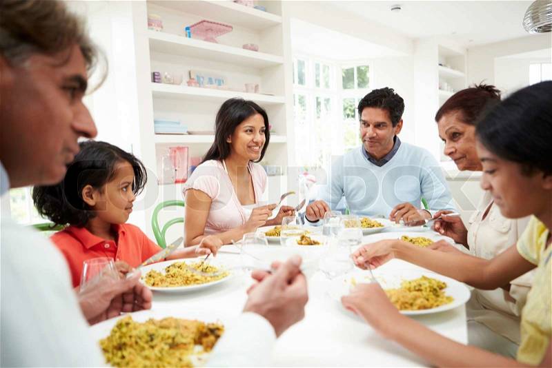 Multi Generation Indian Family Eating Meal At Home, stock photo