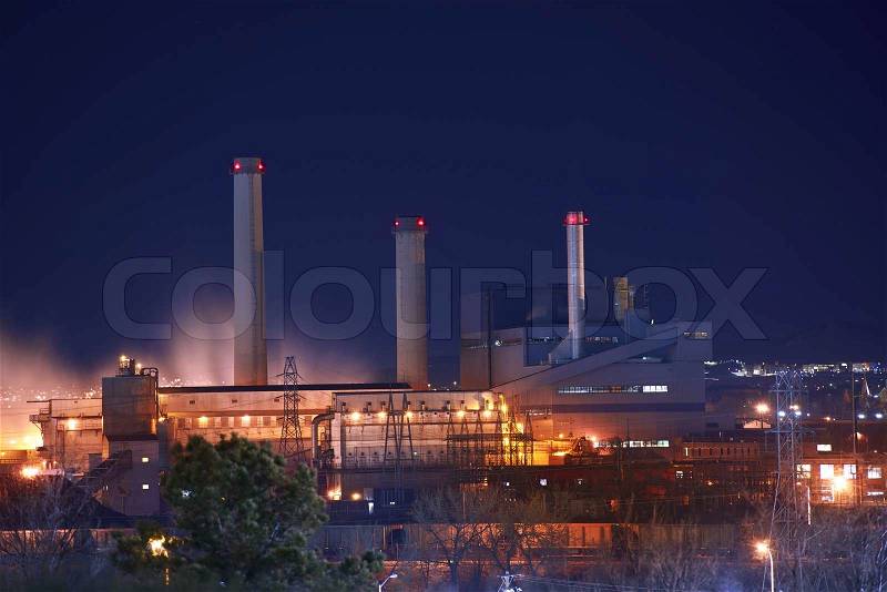 Industrial Zone at Night. Industrial Buildings Illumination and Smoke, stock photo