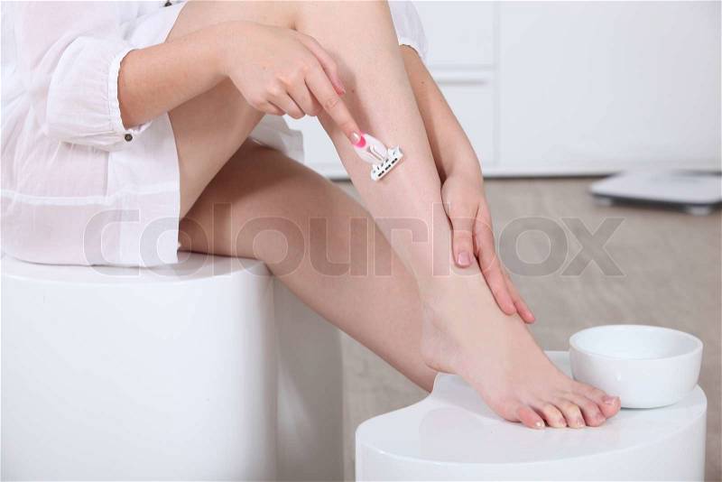 Woman shaving her legs, stock photo