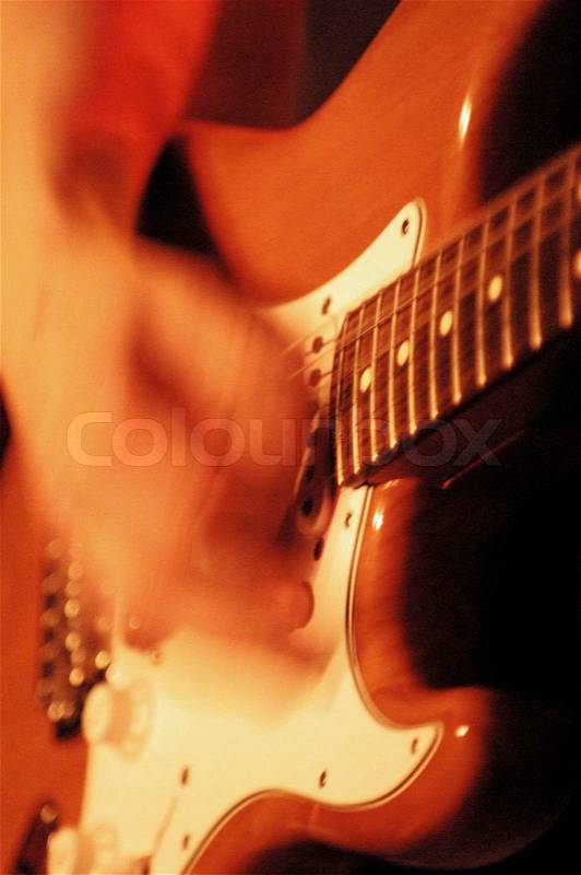 Close-up on blurred hand playing electric guitar, stock photo