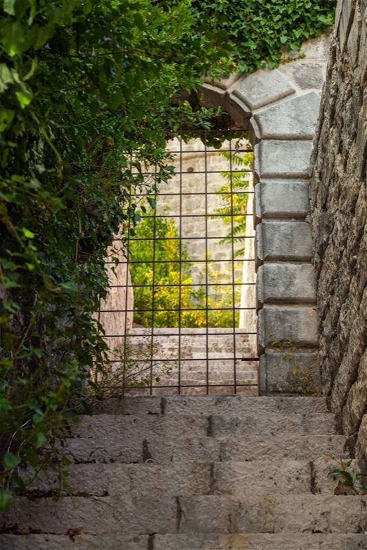 Stone gate locked with rusted steel grating, stock photo