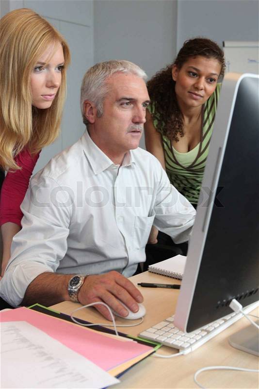 Teacher and students working together, stock photo