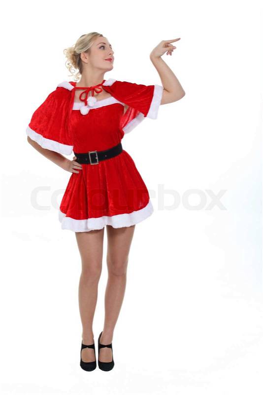 Gorgeous blonde in christmas outfit pointing to her side, stock photo