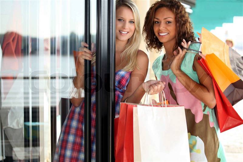 Portrait of two girls with shopping bags, stock photo