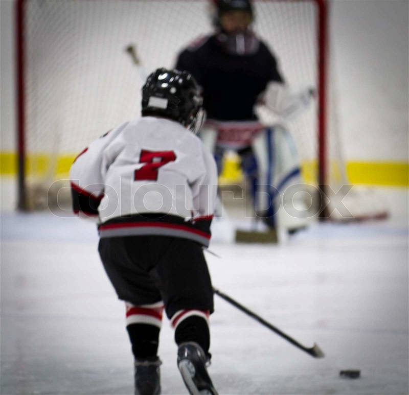 Child playing ice hockey on a breakaway, stock photo