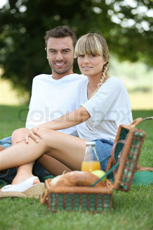 Couple having picnic in the park, stock photo