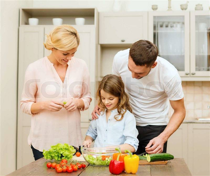 Food, family, hapiness and people concept - happy family making dinner in kitchen, stock photo