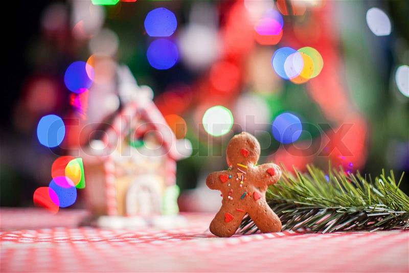 Close-up of gingerbread man background candy ginger house and Christmas tree lights, stock photo