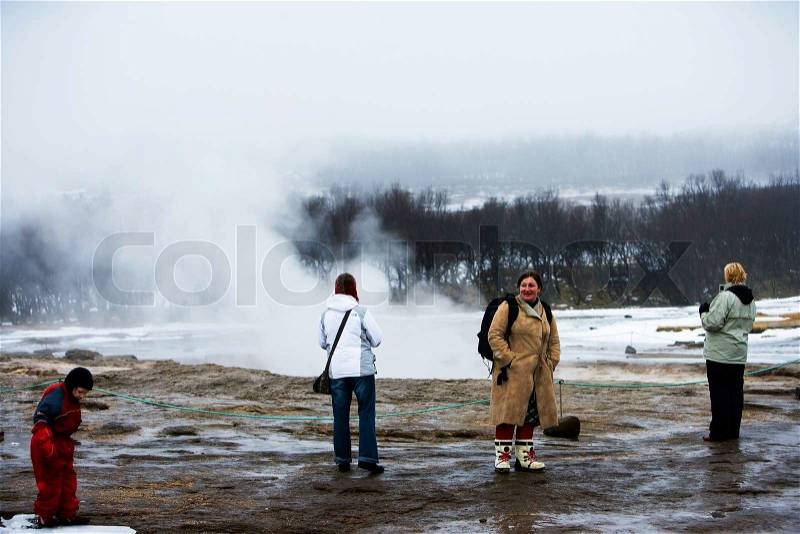 People watching geyser in Iceland, stock photo