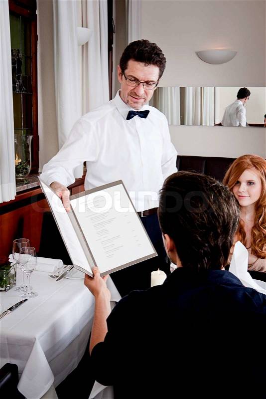 Man and woman in restaurant waiter bring card and order food, stock photo