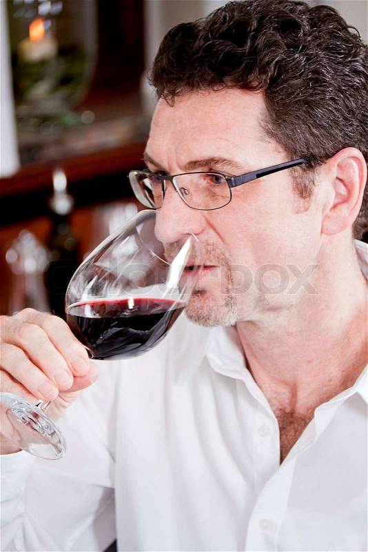 Man and woman in restaurant for dinner drinking red wine and smiling, stock photo