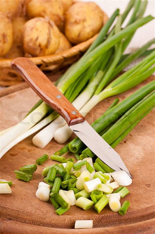 Green onions cut on a wooden board, stock photo