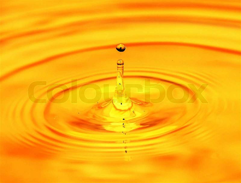 Abstract background. A drop of water falls in gold, stock photo