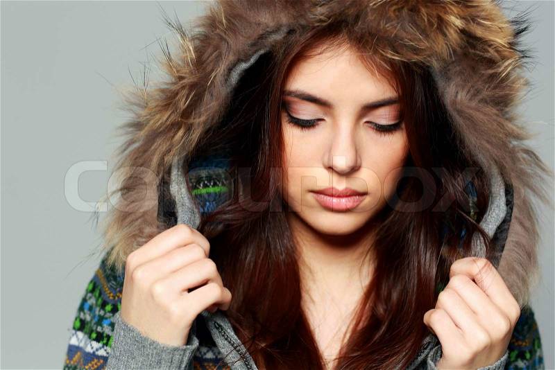 Closeup portrait of a young woman in warm winter outfit with closed eyes, stock photo