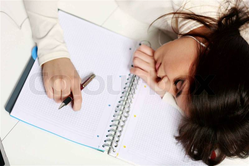 Young tired student fallen asleep at the table, stock photo