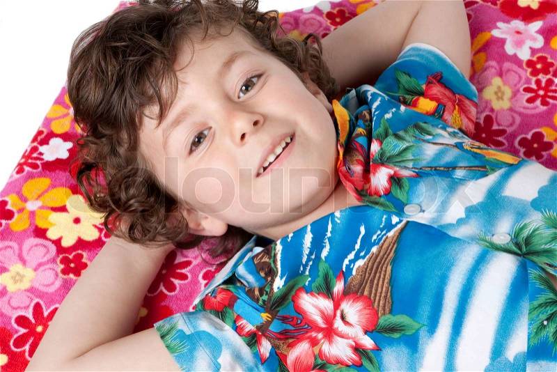 Beautiful boy lying relaxed on the floral towel, stock photo
