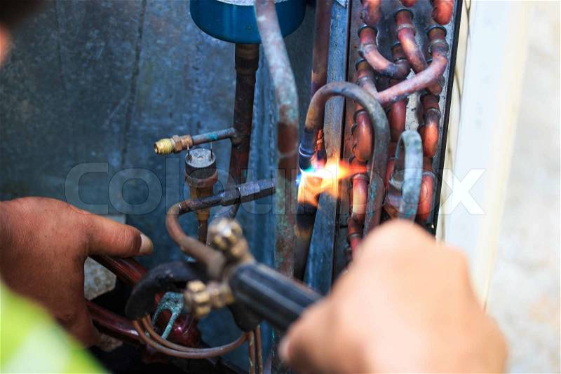 Welding copper pipes and Air conditioner repairman, stock photo