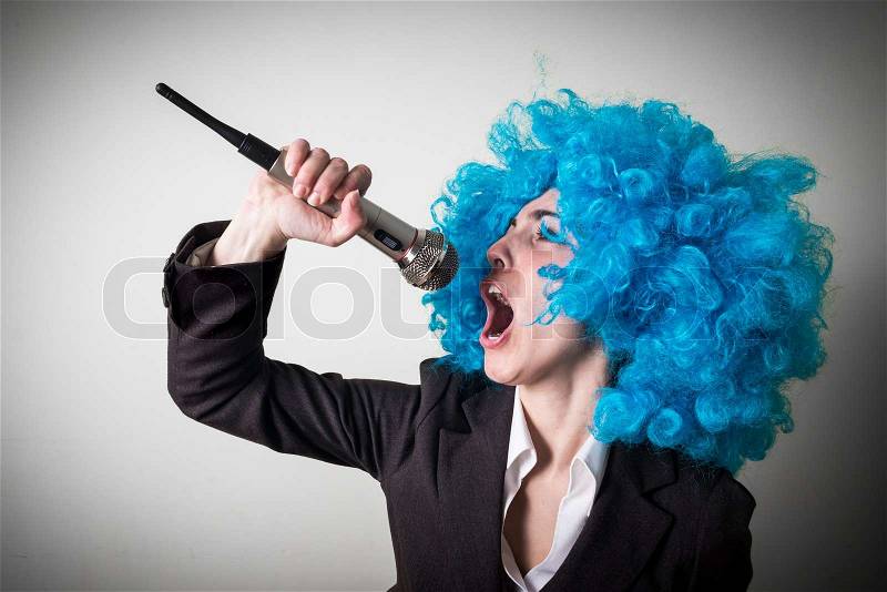 Funny blu wig beautiful young businesswoman on gray background, stock photo