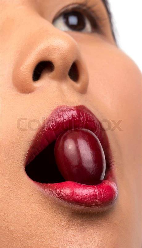 Closeup of woman mouth eating red grape on white, stock photo