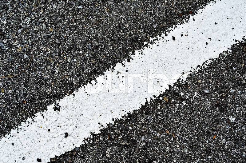 Closeup of a tar or asphalt pavement texture with a white line painted, stock photo