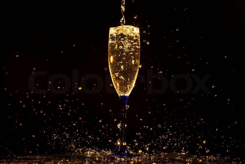 Champagne pouring in glass on a black background, stock photo