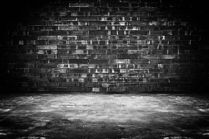 Old dark room with brick wall and concrete floor - as background, stock photo