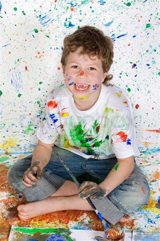 Boy no teeth playing with painting with the background painted, stock photo