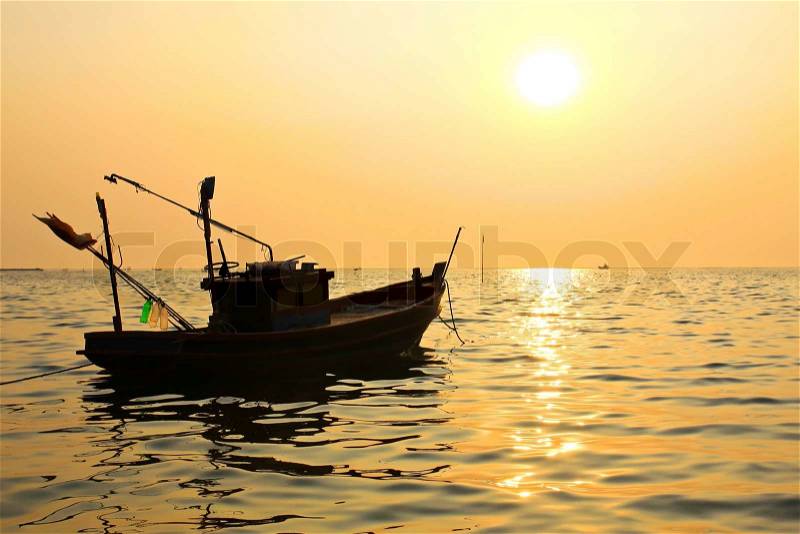 Silhouette of fishing boat at sunset, stock photo