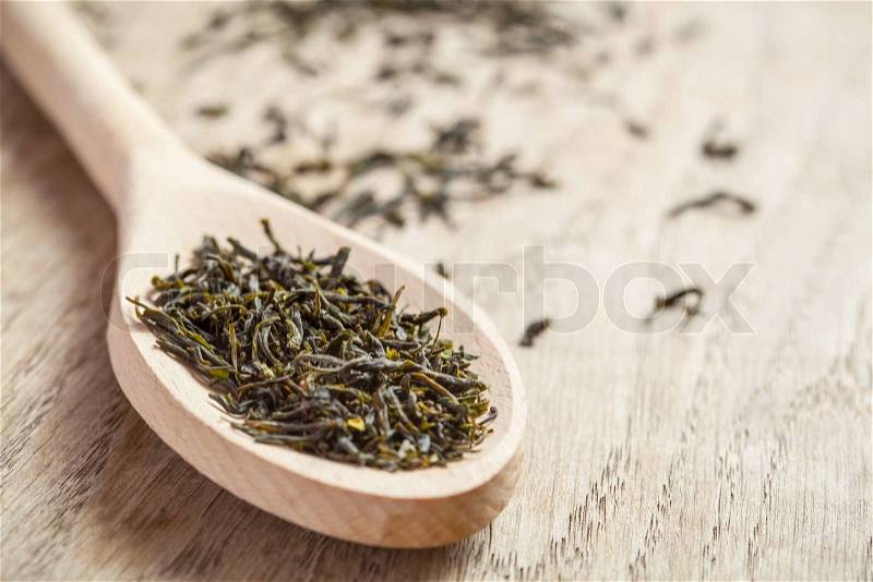 Wooden spoon with grean tea herbs, stock photo
