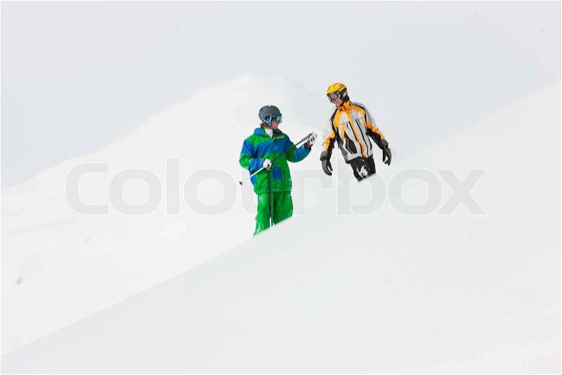 Skier and snowboarder in the snow looking into an alpine winter landscape in anticipation of the next downhill race, stock photo