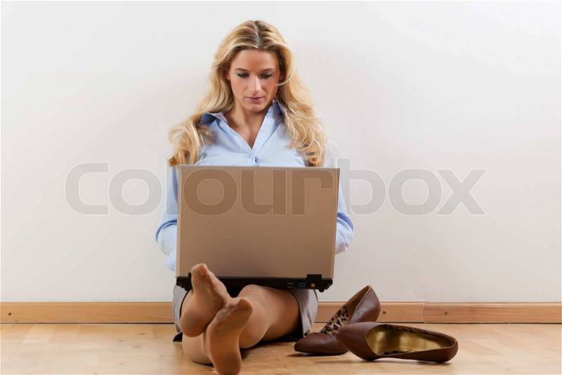Business woman working at home with her laptop on the floor, stock photo