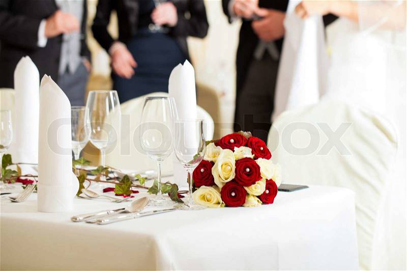 Wedding table at a wedding feast decorated with bridal bouquet, stock photo