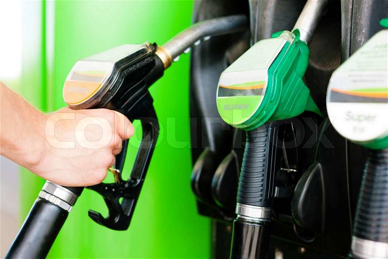 Refuel the car on a gas station; man taking the tap, stock photo