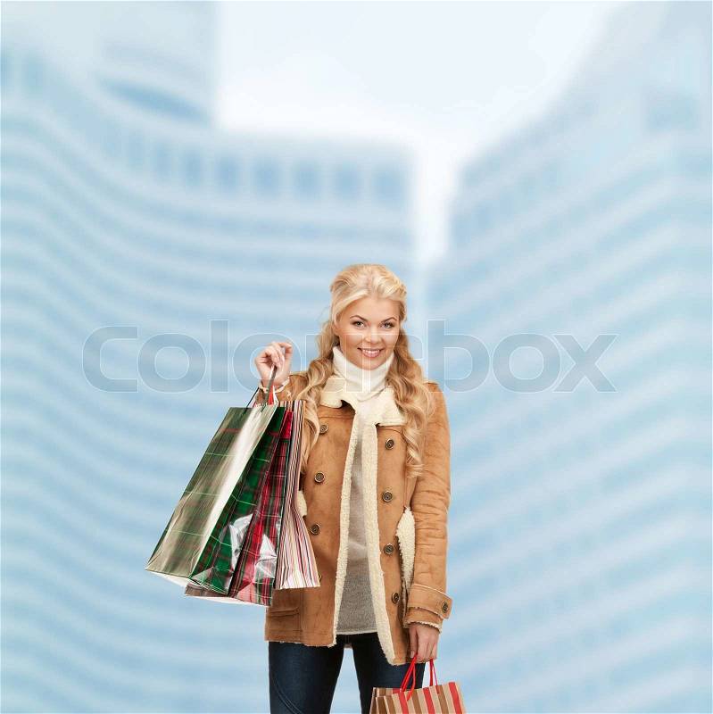 Shopping and sale concept - lovely woman with shopping bags outdoors, stock photo