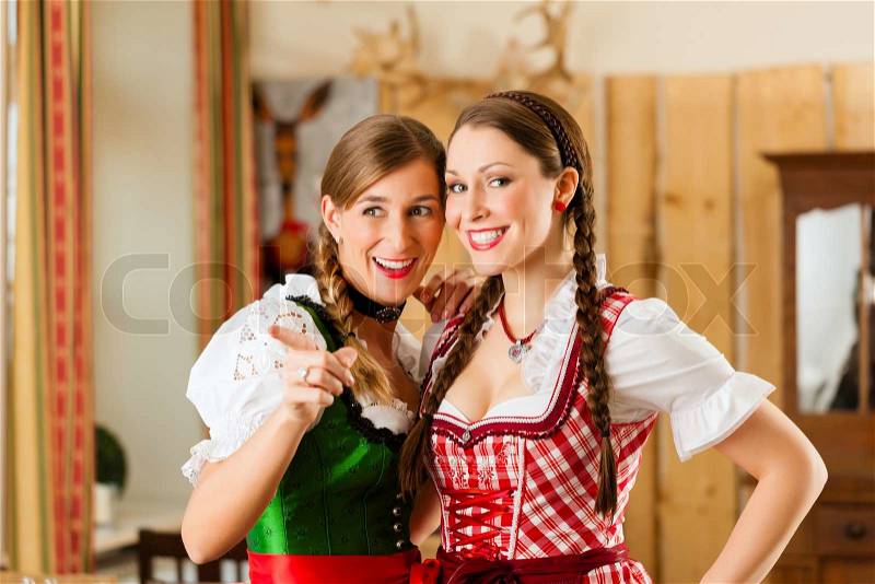 Young people - two women - in traditional Bavarian Tracht in restaurant or pub , stock photo