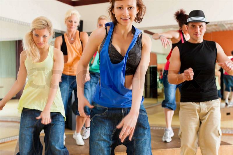 Zumba or Jazzdance - young people dancing in a studio or gym doing sports or practicing a dance number, stock photo