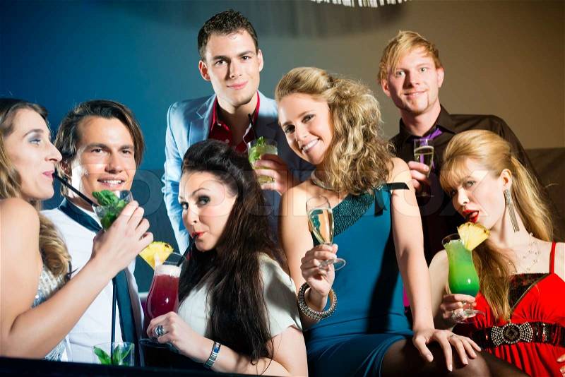 Young people in club or bar drinking cocktails and having fun, stock photo
