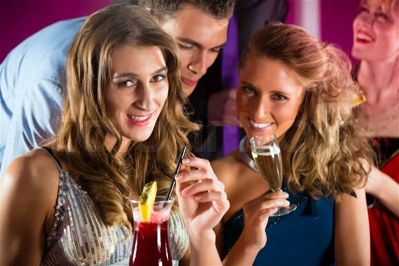Young people in club or bar drinking cocktails and having fun, stock photo