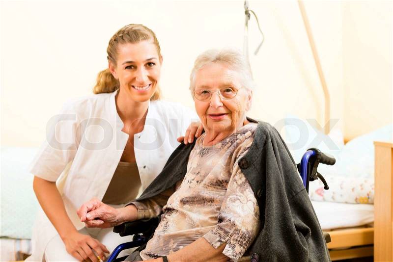 Young nurse and female senior in nursing home, the old lady sitting in a wheel chair, stock photo