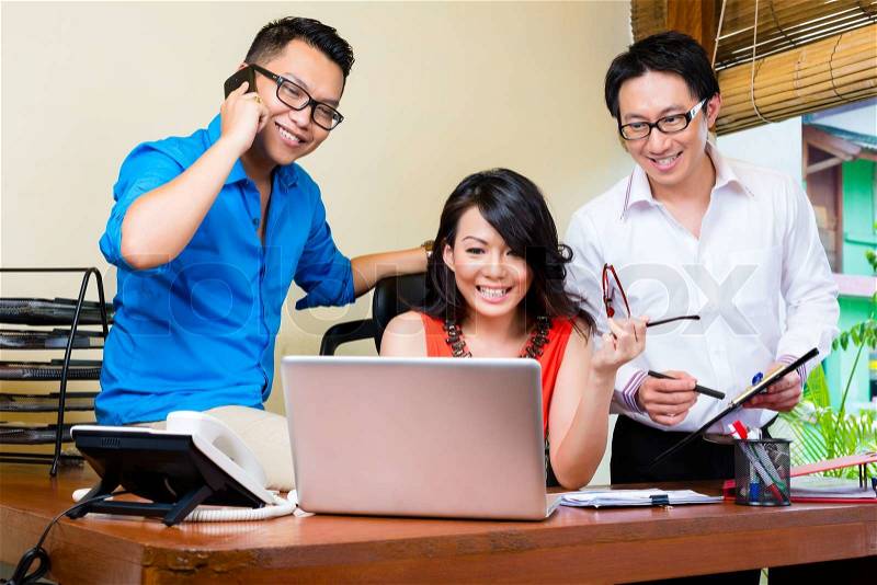 Asian Creative agency - team meeting in an office with laptop, stock photo