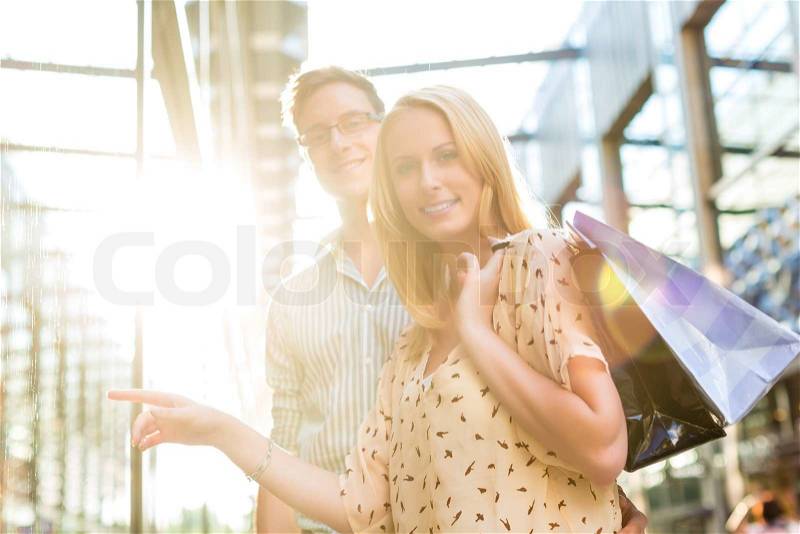 Couple shopping in the free time in the sun with shopping bag, stock photo