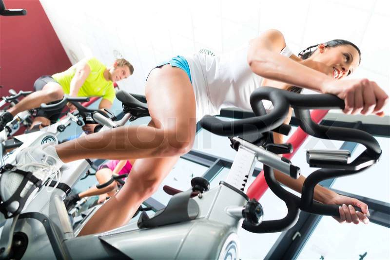 Young People - group of women and men - doing sport Spinning in the gym for fitness, stock photo