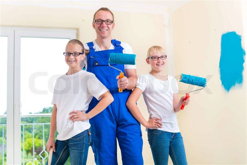 Father and his daughters or daughter with her friend are painting with paint roller a wall in blue, stock photo