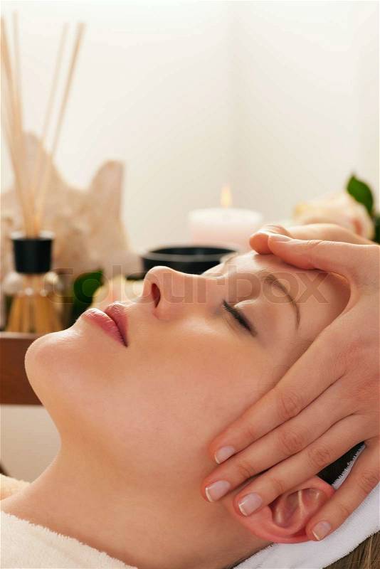 Beautiful woman enjoying a face massage competently carried out in a spa, stock photo