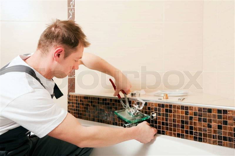 Plumber installing a mixer tap in a bathroom, he is sitting in the bathtub, focus on eyes of the man!, stock photo