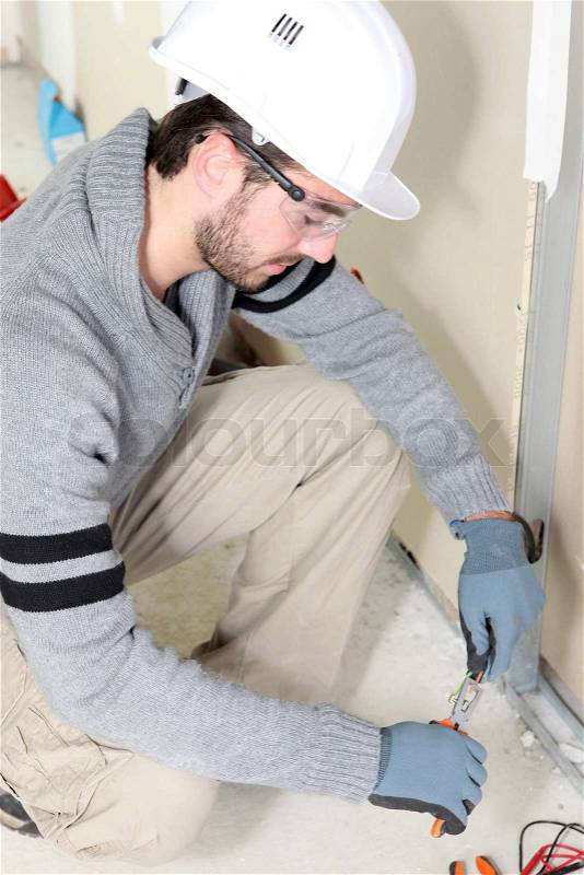 Electrical worker testing socket, stock photo